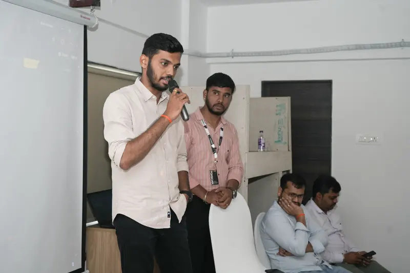 A FoxScan team member answers questions on a microphone while colleagues listen.